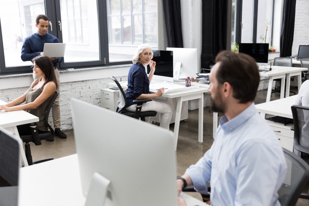 Group of business people talking to each other while working together at the office